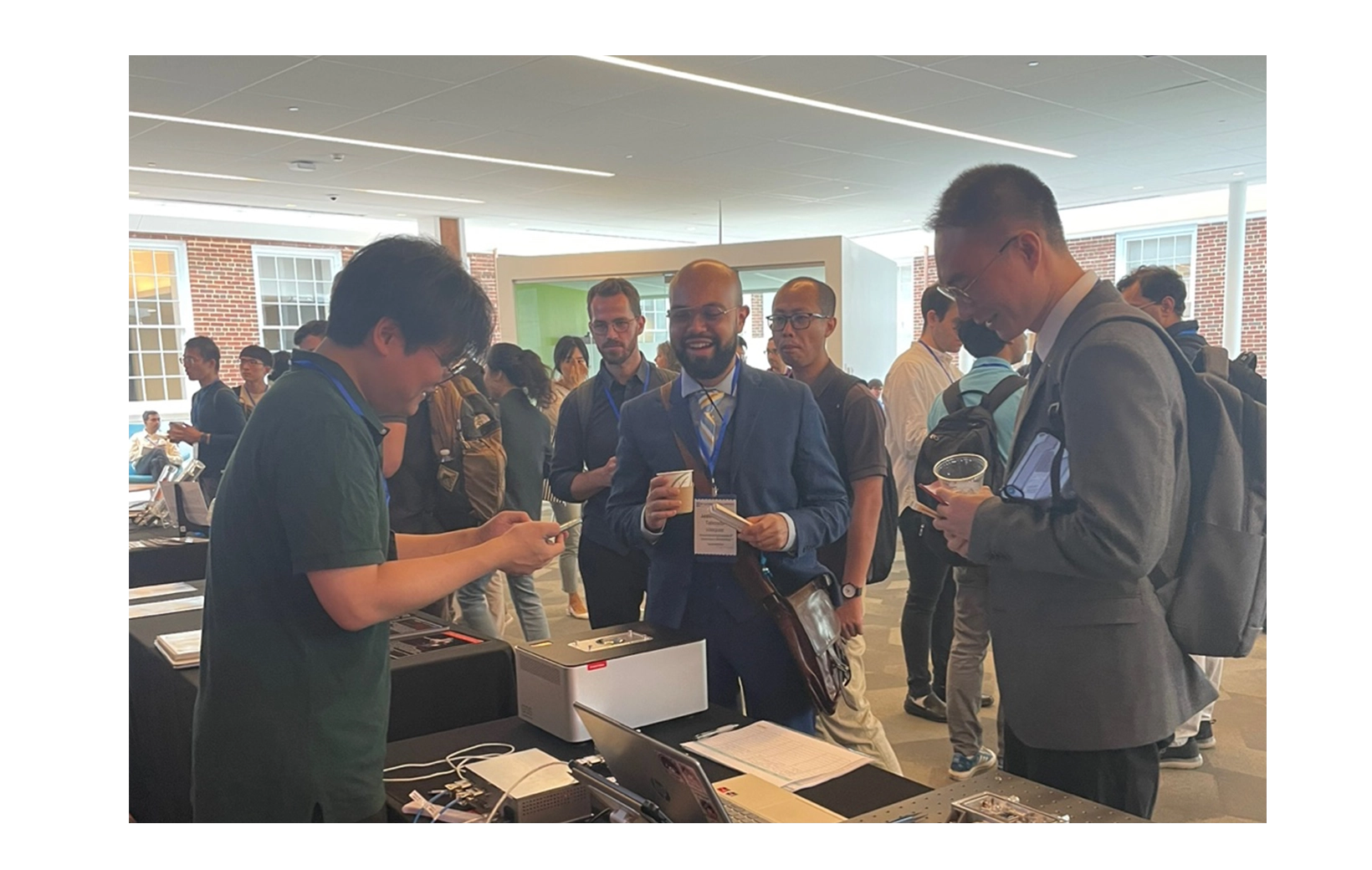 Employees and smiling customers explaining things to customers who visited the Nextron promotional booth at the 2024 EMC&DRC